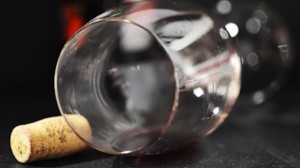 An image of an empty wine glass and a cork.