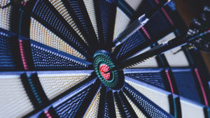 An image of a darts board with a dart hitting the bulls-eye.