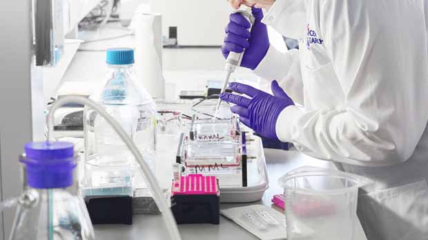 A photograph of a scientist using a pipette in the lab.
