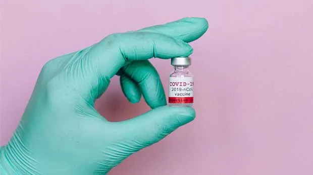 Hand holding a COVID-19 vaccine