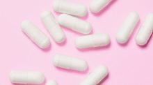White pills on a pink background