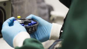 Researcher handling vials of chemicals