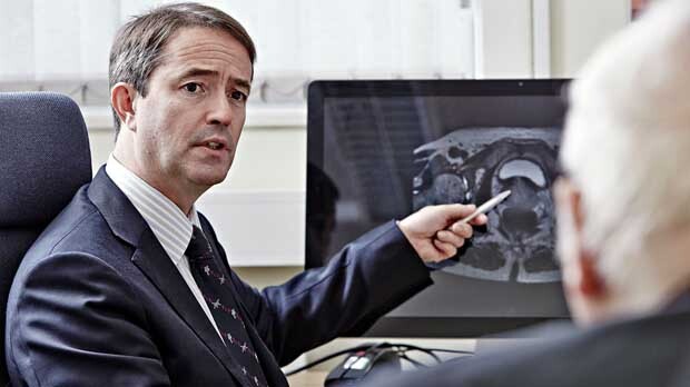 A doctor shows a patient a prostate scan