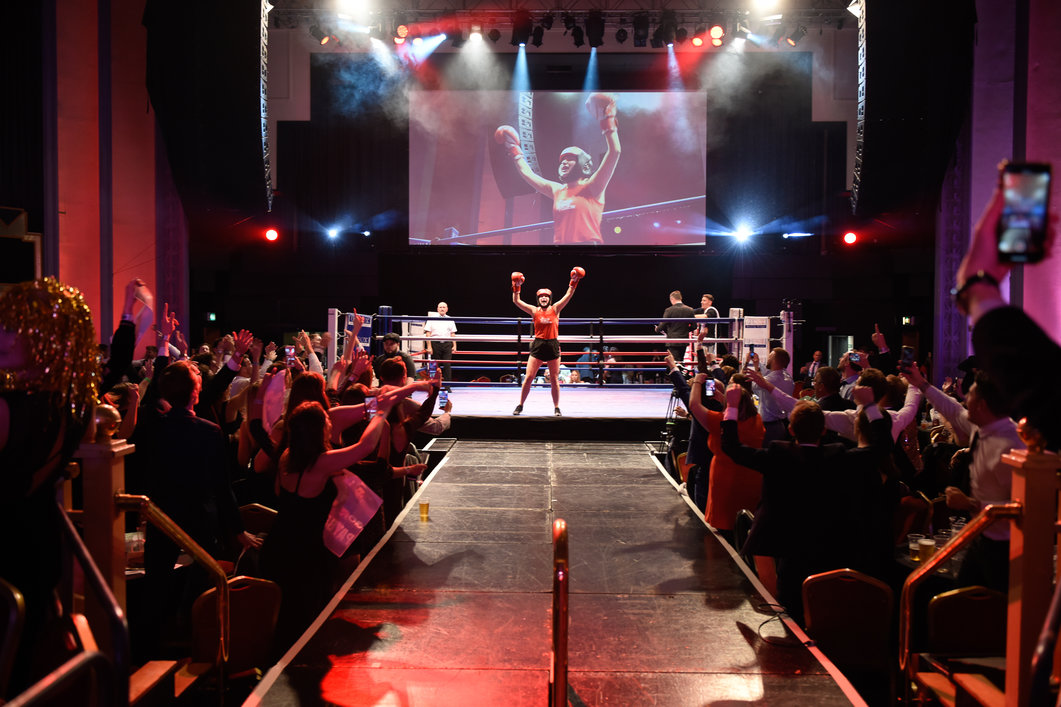 Ultra White Collar Boxing participant celebrating in the ring as the audience cheer