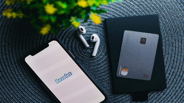 Image of the Revolut app on a smartphone and a Revolut card