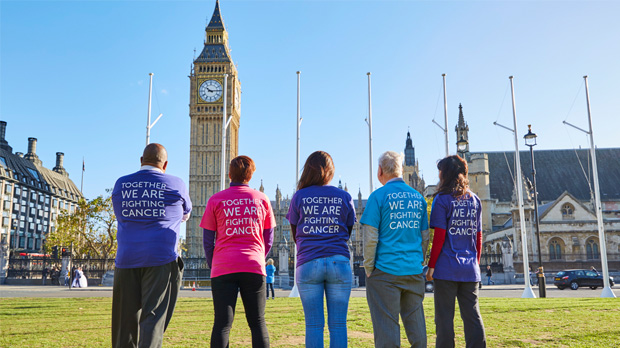 Cancer Research UK supporters standing in front of Parliament wearing shirts that say 'Together we are fighting cancer'