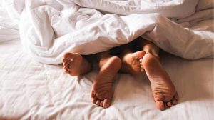 Two people's feet in bed.