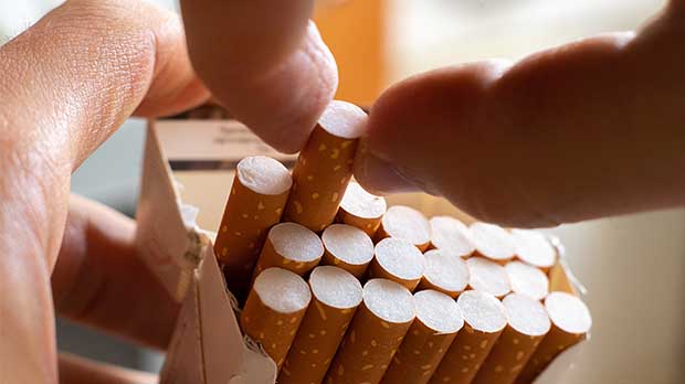 Hand pulling out a cigarette