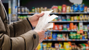 A person reading various receipts in a supermarket