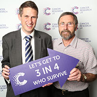 A photograph of Alan Peace and his MP Gavin Williamson holding a sign which reads 'Let's get to 3 in 4 who survive'.