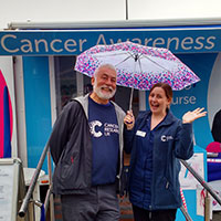 A photograph of Dave at a Cancer Awareness Roadshow and Jess, Cancer Awareness Nurse