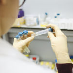 A photograph of someone holding a test tube in a lab.