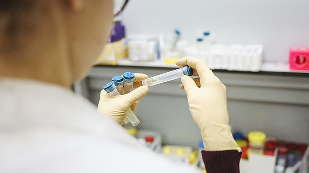 A photograph of someone holding a test tube in a lab.