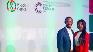 Black in Cancer co-founders Dr Henry Henderson and Sigourney Bonner on stage at the start of teh Black in Cancer conference