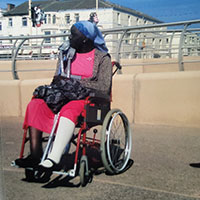 Maria in a wheelchair following her treatment