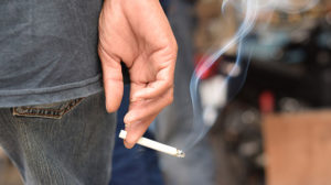 A person holding a lit cigarette