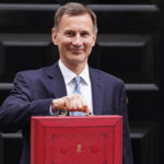 Image of Jeremy Hunt holding the red budget briefcase