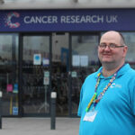 Brett outside the Cancer Research UK shop he volunteers in