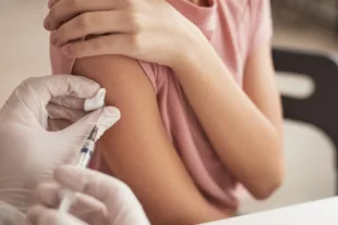 An unrecognisable young girl receiving a vaccination.
