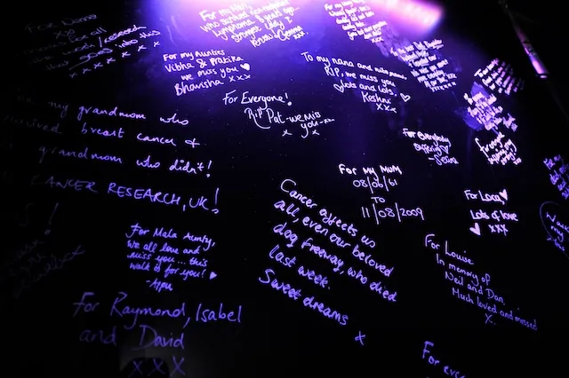 Messages written in glow in the dark pen at a Shine night walk event to remember lost loved ones