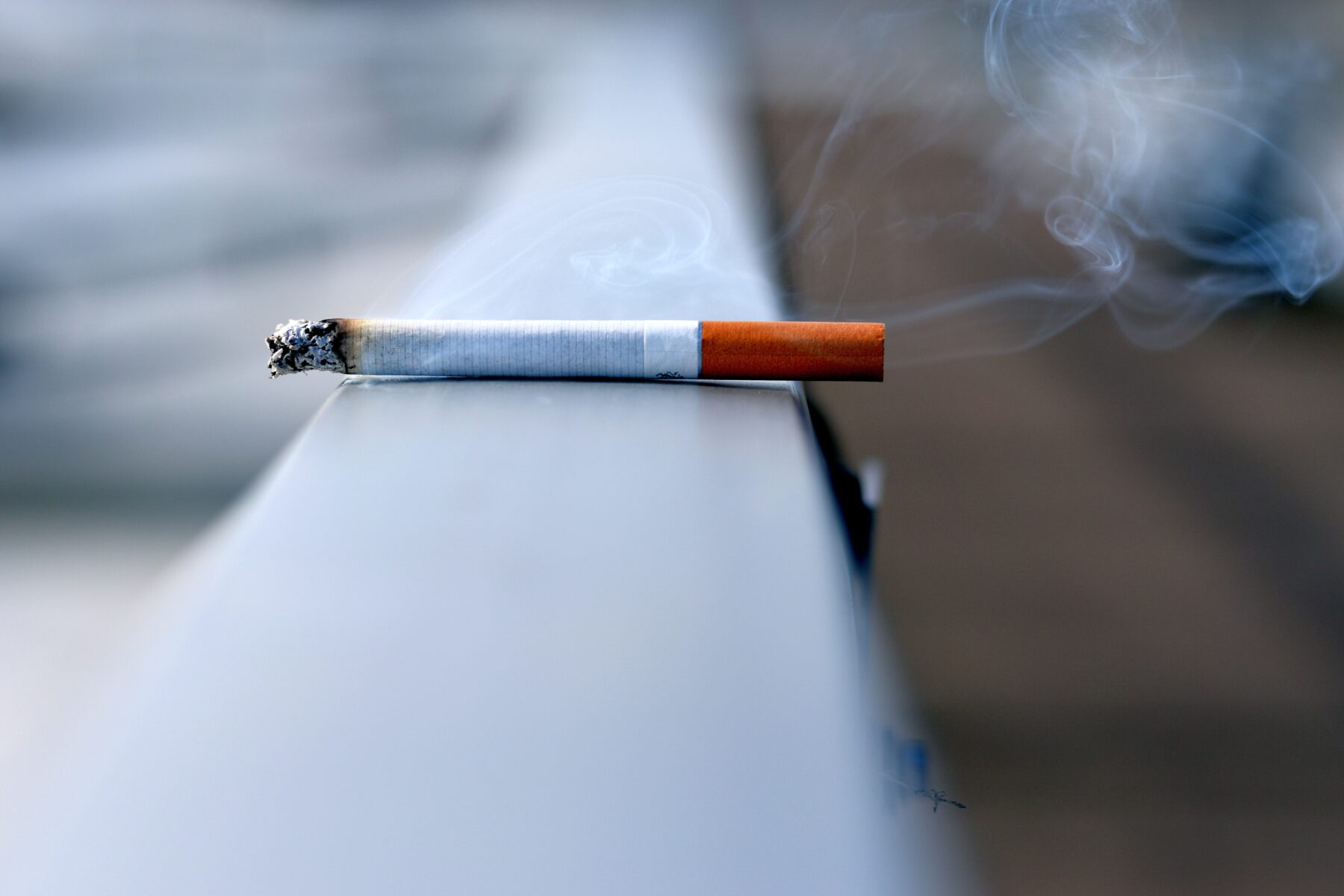 Burning cigarette on railing