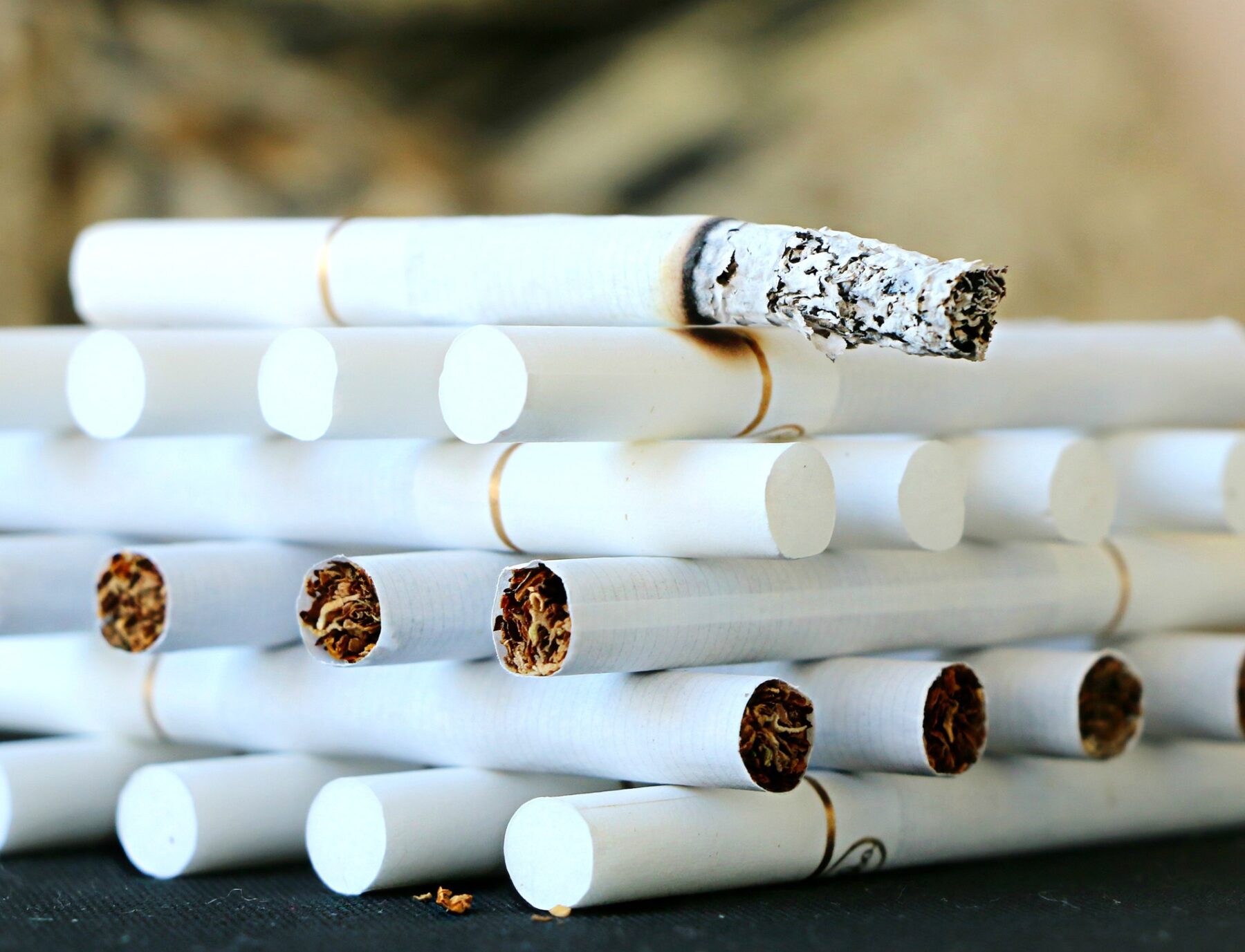 A stack of cigarettes, one of them smoking