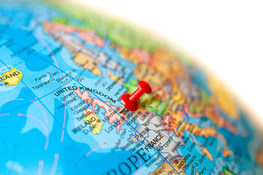 A close up of the UK on a globe, with a red pin marking its location