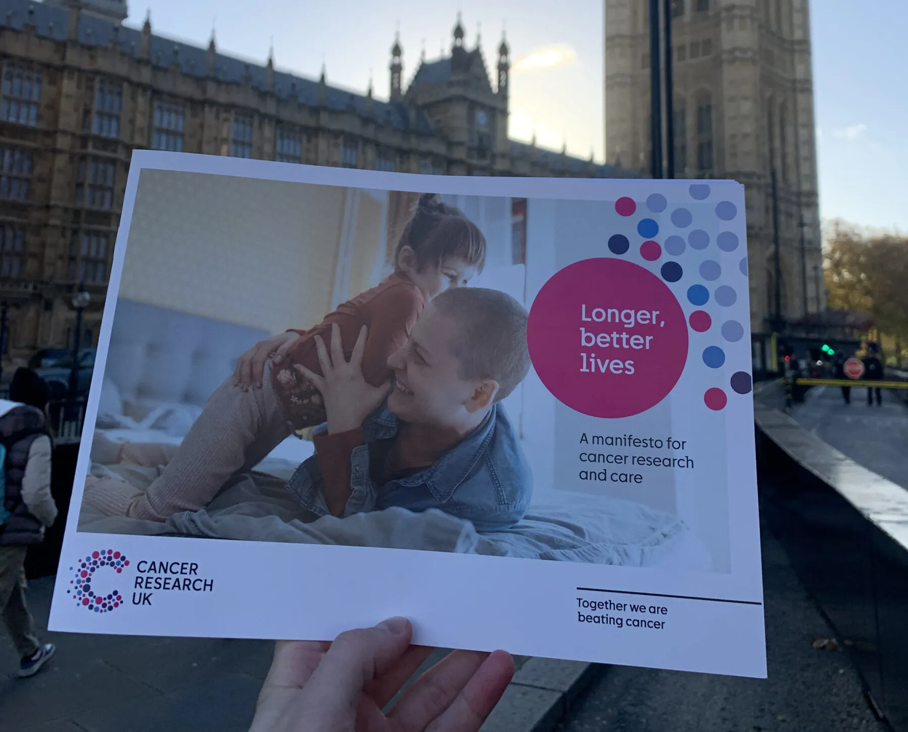 An image of Longer, better, lives: A manifesto for research and care, being help up outside of Westminster