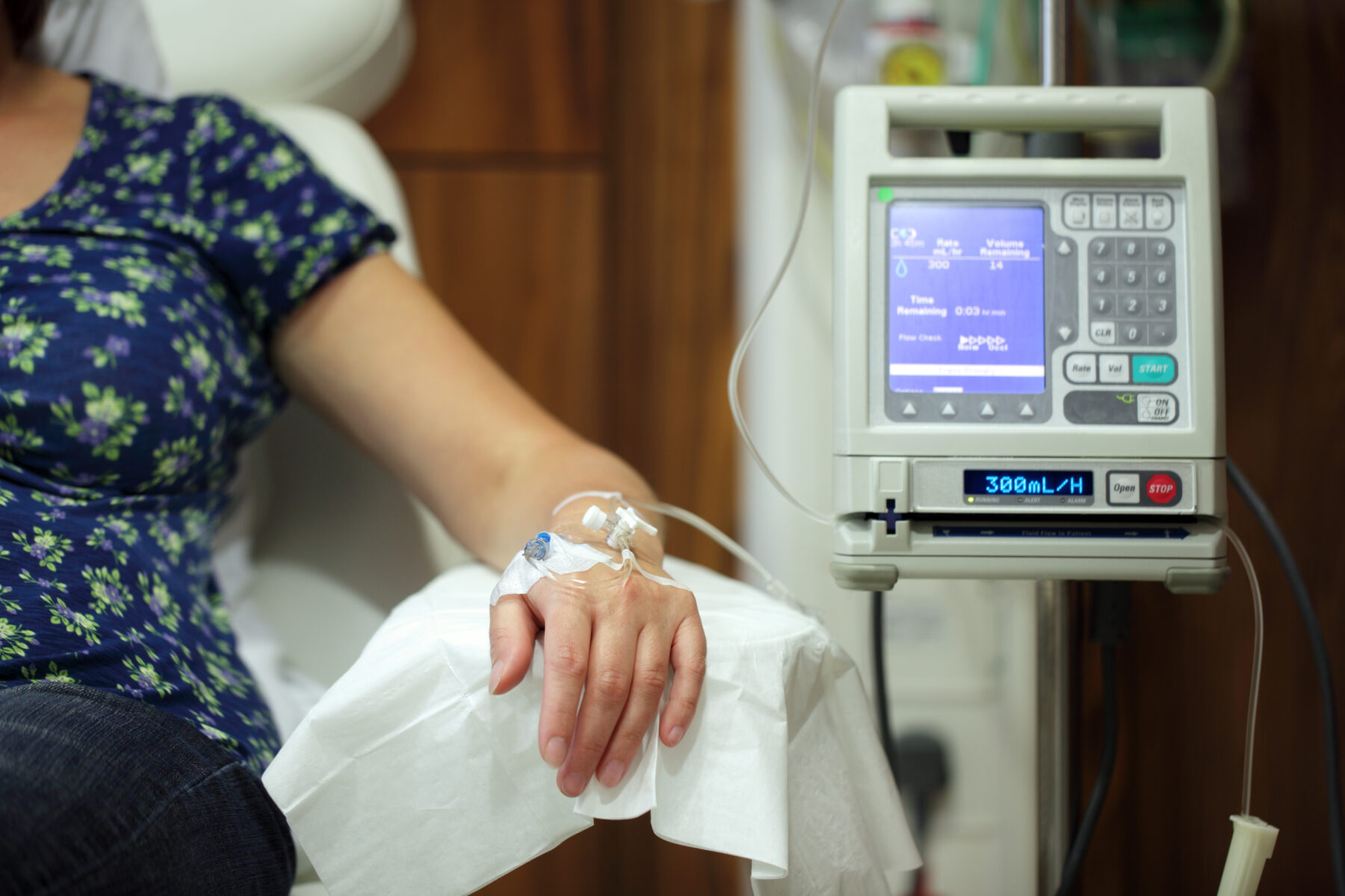 Infusion pump feeding IV drip into patients arm