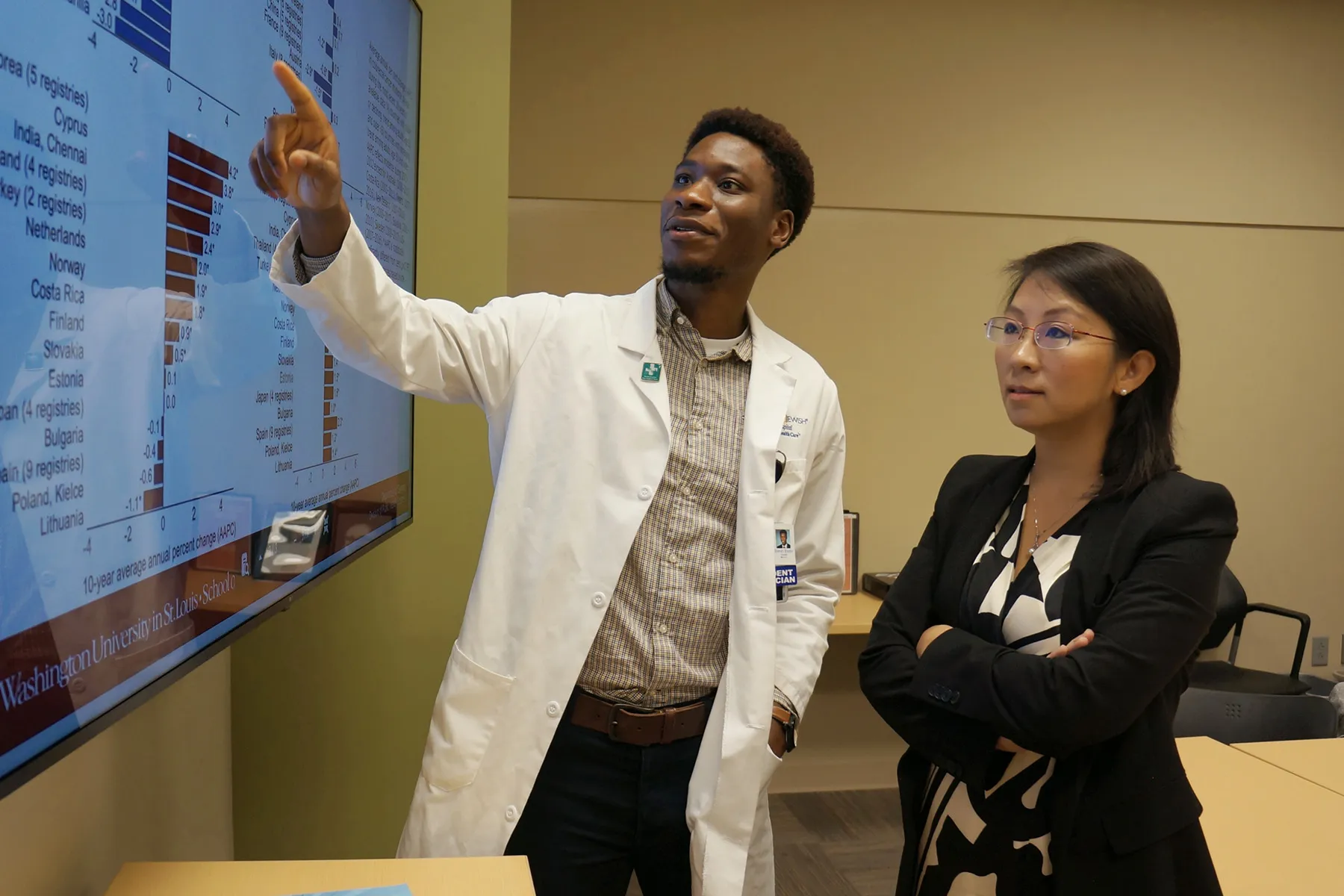 Dr Yin Cao and a colleague looking at data about cancer incidence.