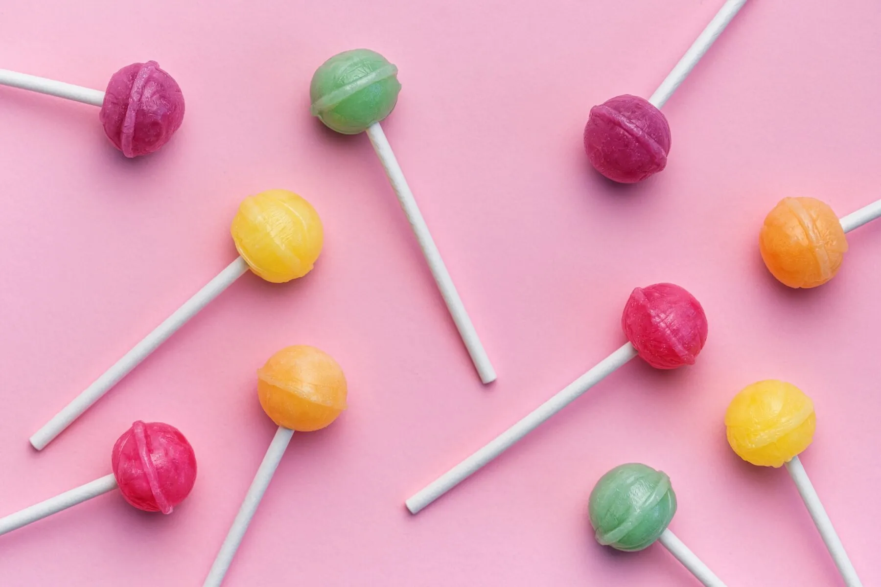 Colourful lollipops on a pink background.