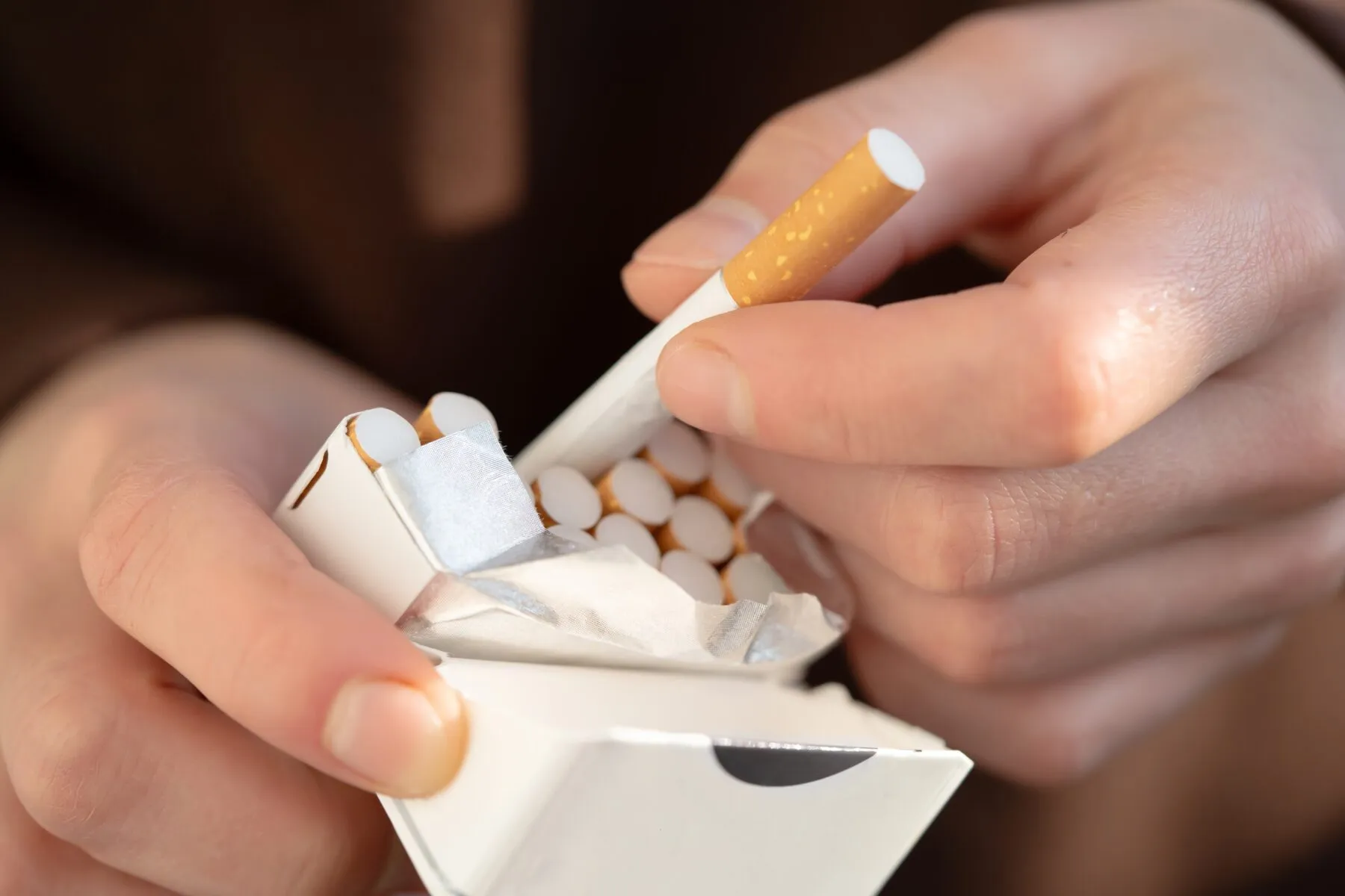 A cigarette being removed from a packet