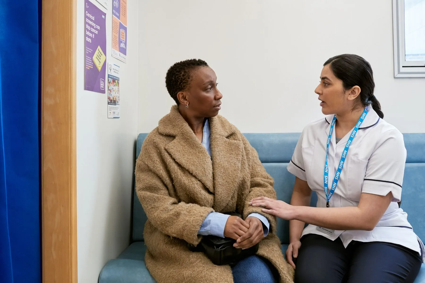 A woman speaking to a nurse at her breast screening appointment