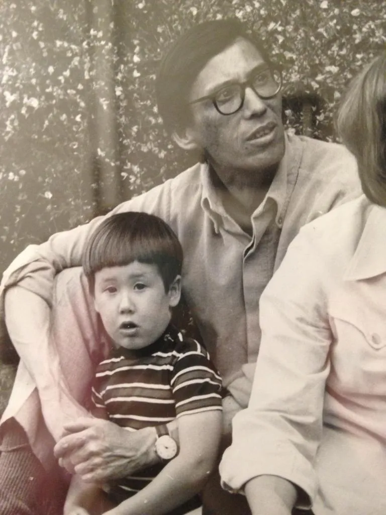 A black and white photo of Gower as a young child sitting outside next to his dad