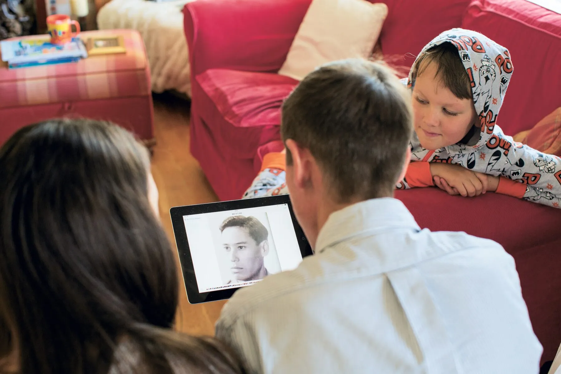 Gower and his children looking at an ipad showing a photo of Gower's father