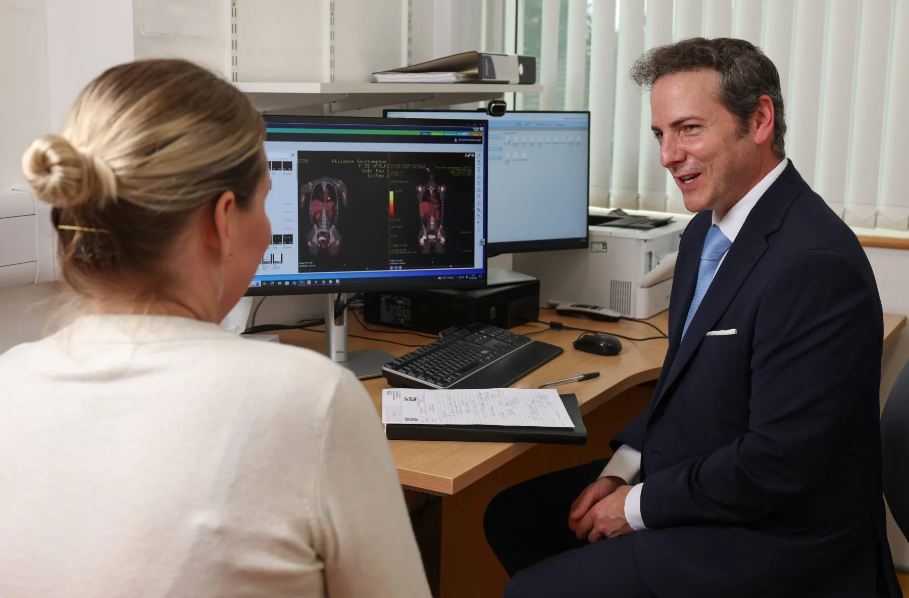 Lina speaks to Dr Hugo De La Pena who is looking at cancer scans on a computer screen