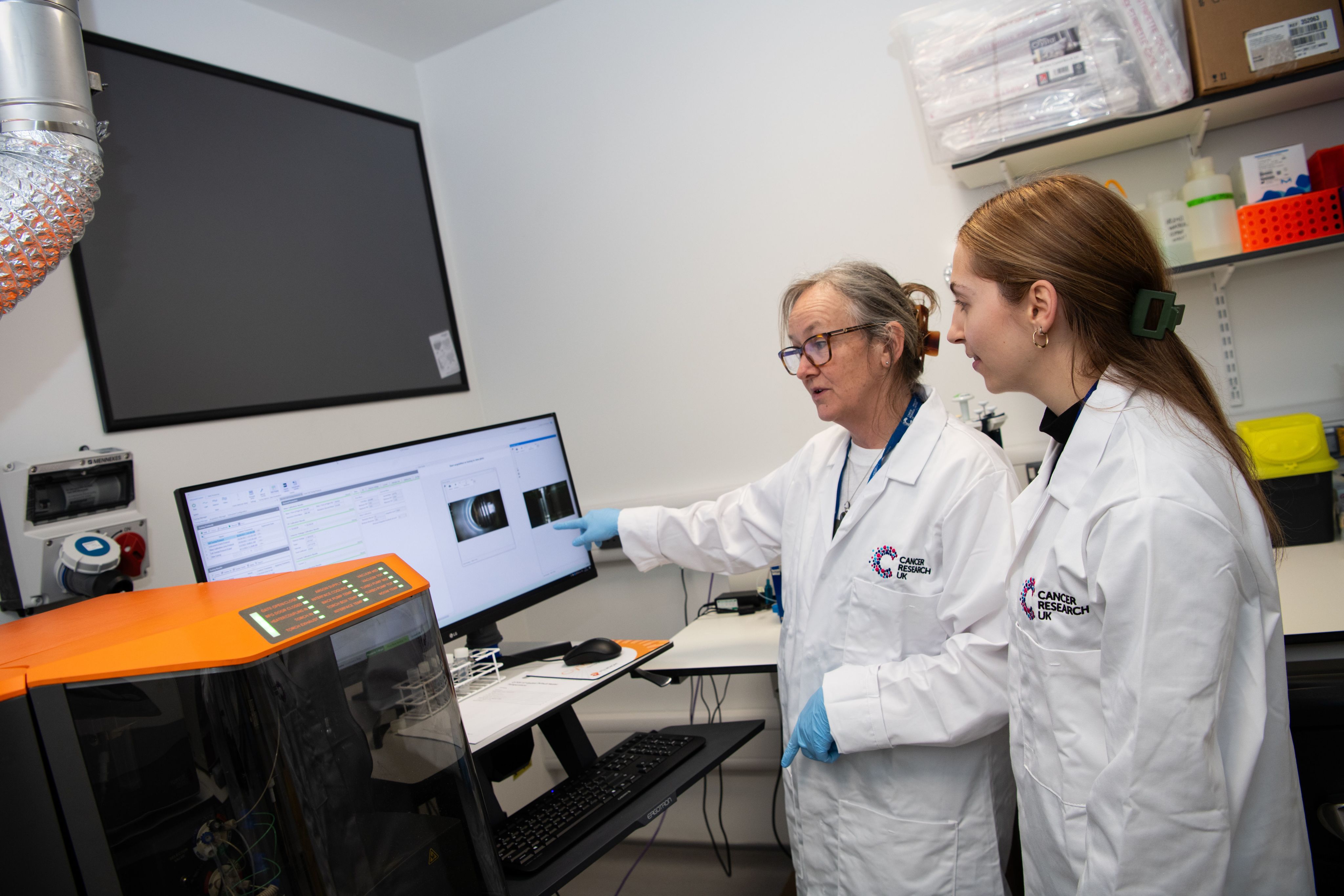 Two researchers looking at a screen
