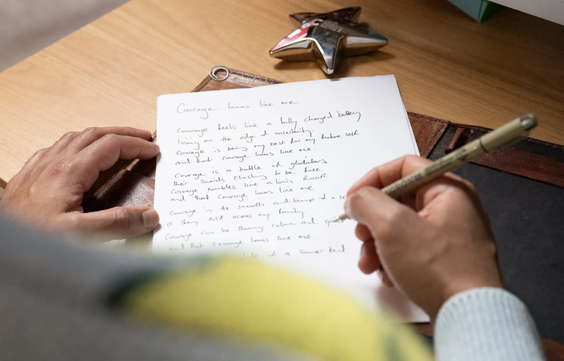 Joseph Coelho writes his poem on a piece of paper