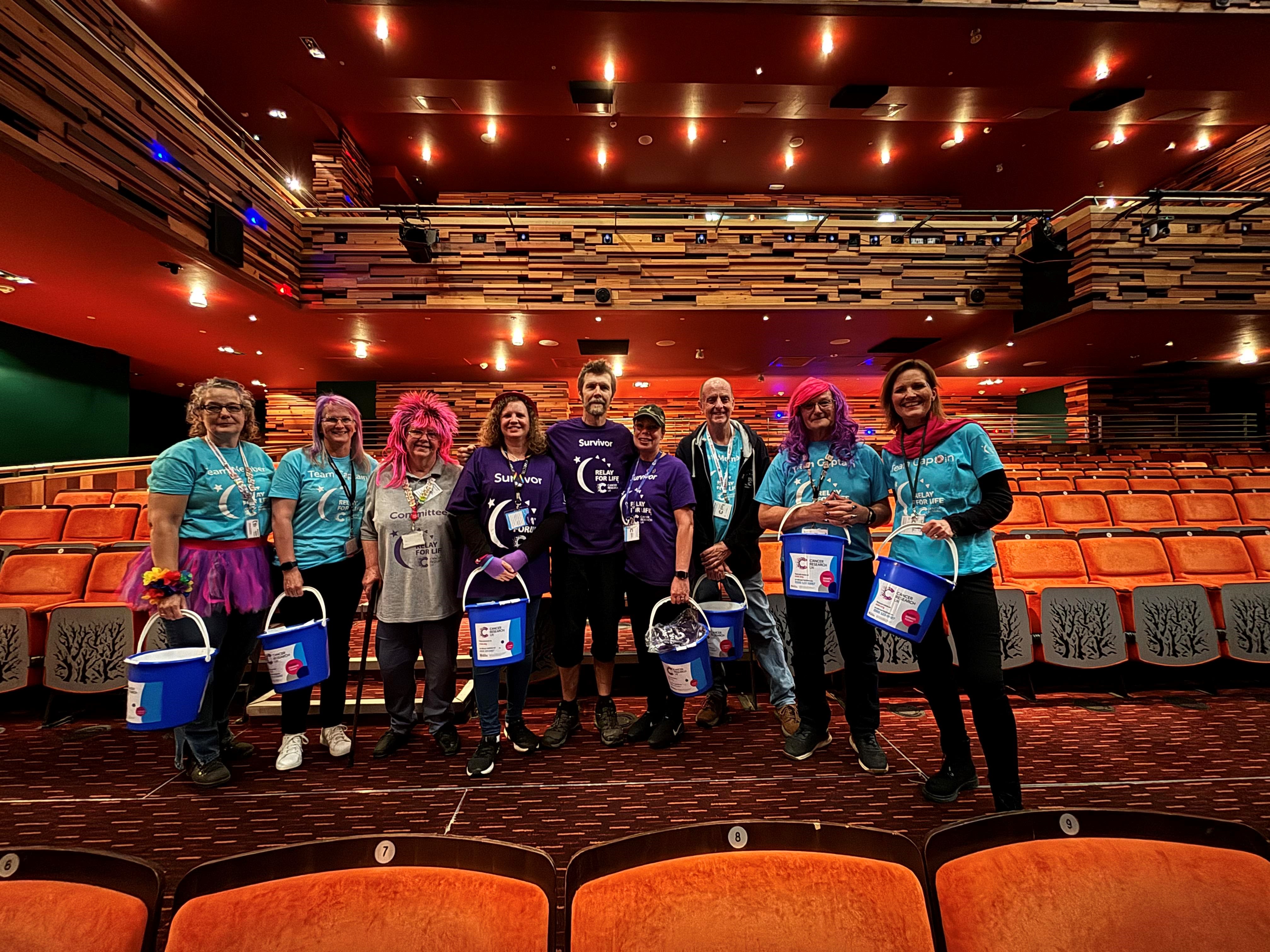 A group of volunteers with collection buckets, with Rhod Gilbert standing in the centre