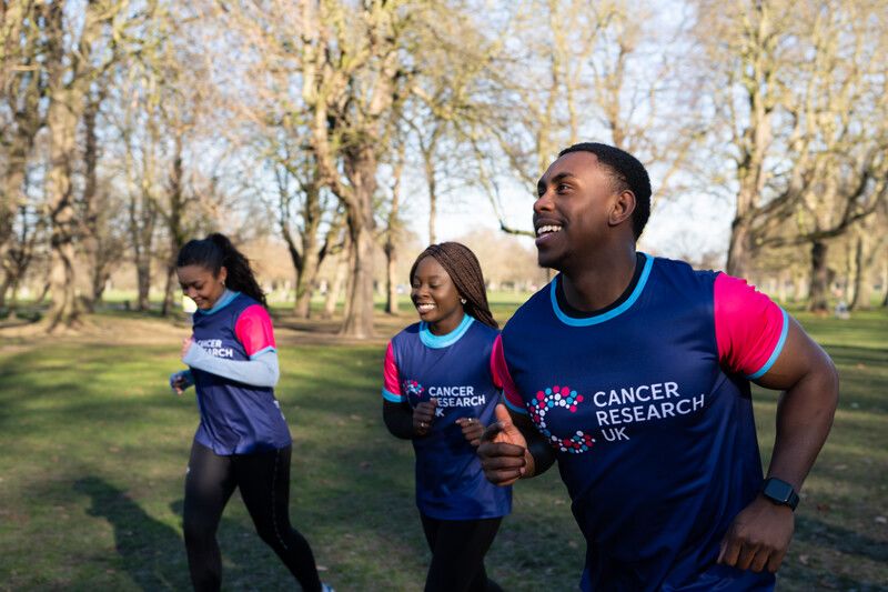 Three people running in Cancer Research UK branded tshirts