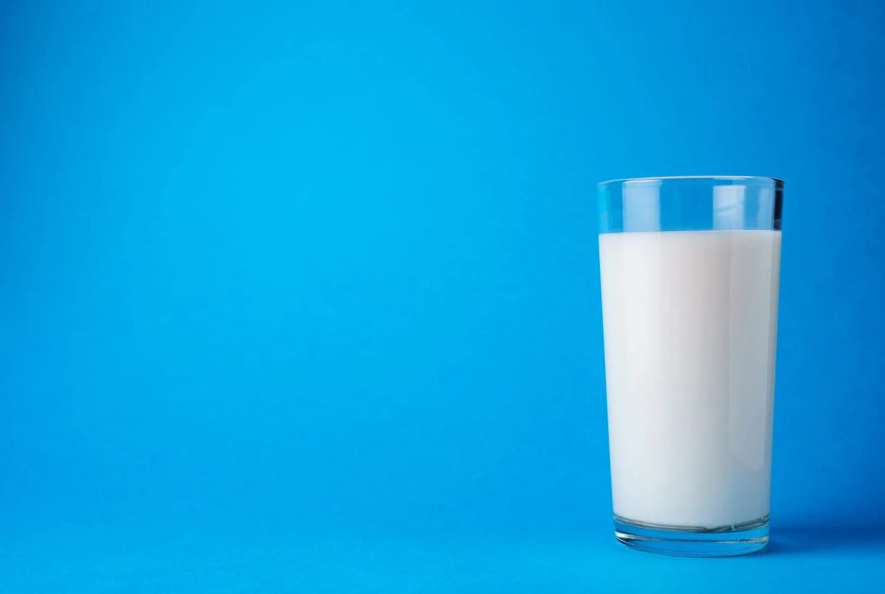 glass of milk with a blue background