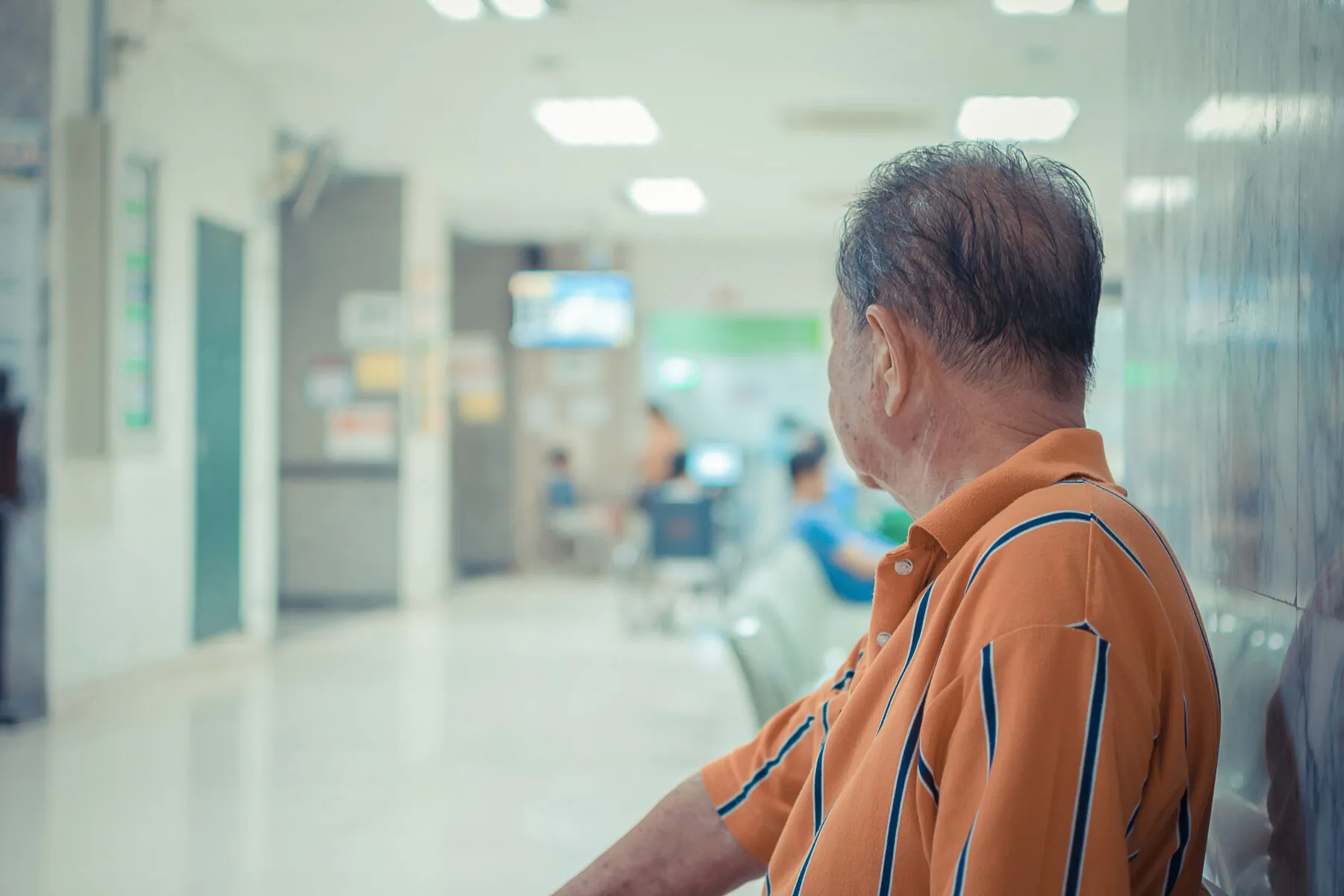 Patient seated at hospital, waiting for a doctor.