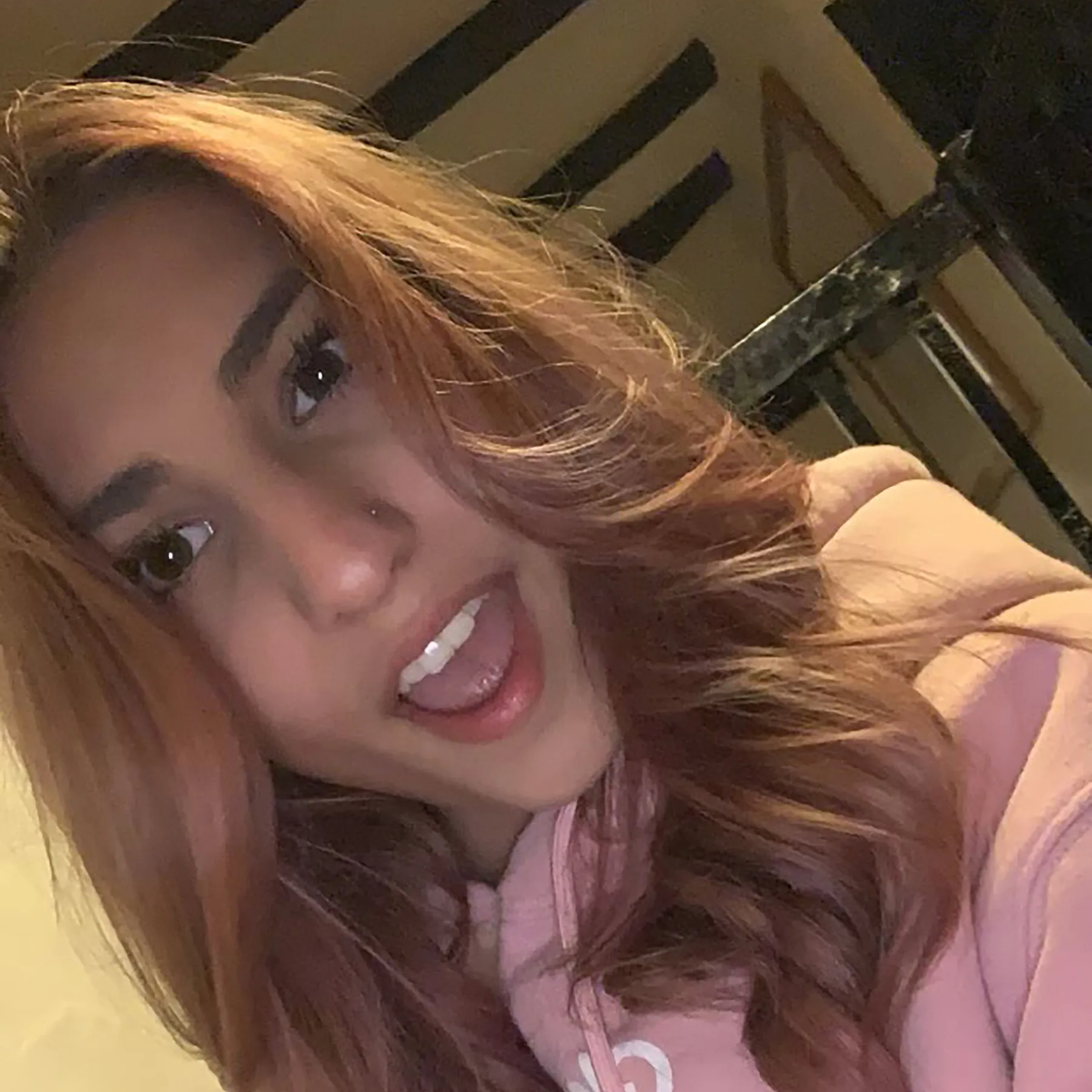 A selfie of Asha in a pink hoodie.