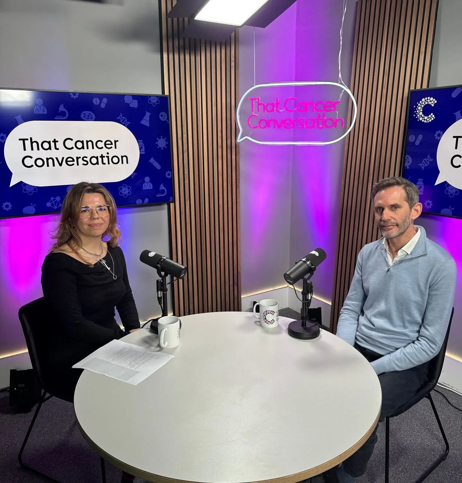 Sophie (left) with Professor Marc Gunter (right) in the podcast studio with a lights saying 'That Cancer Conversation'