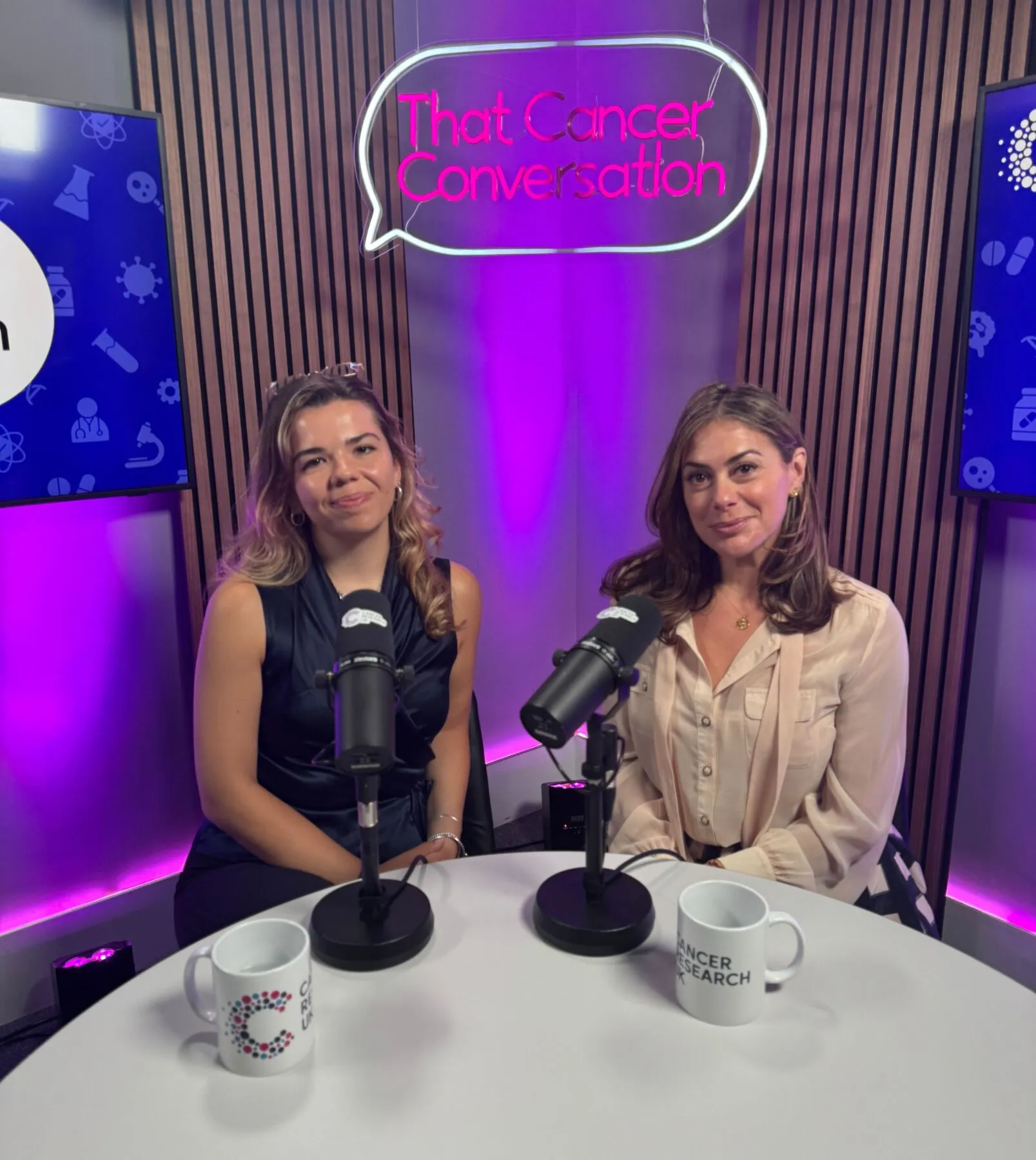 Sophie and Katie Nicholl at the podcast studio in front of microphones