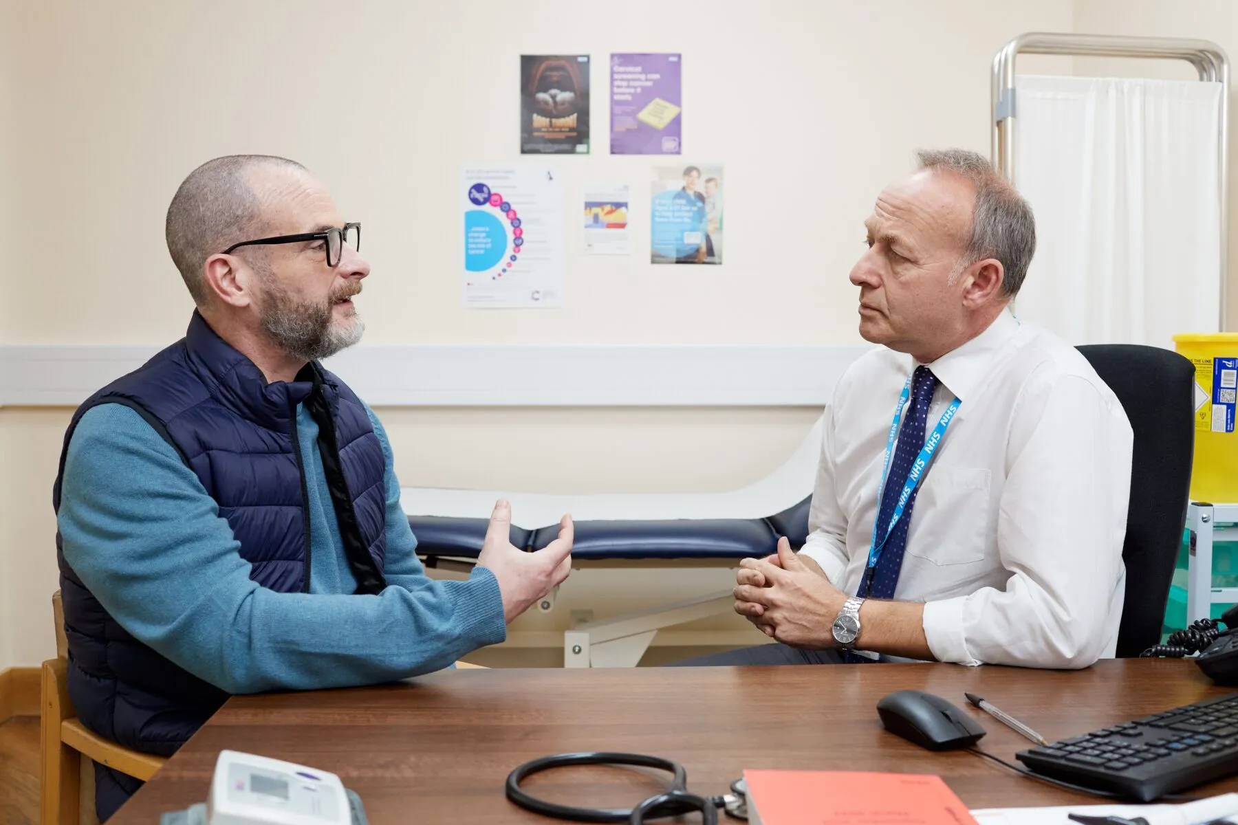 A patient and a GP having a discussion in the GP's office.