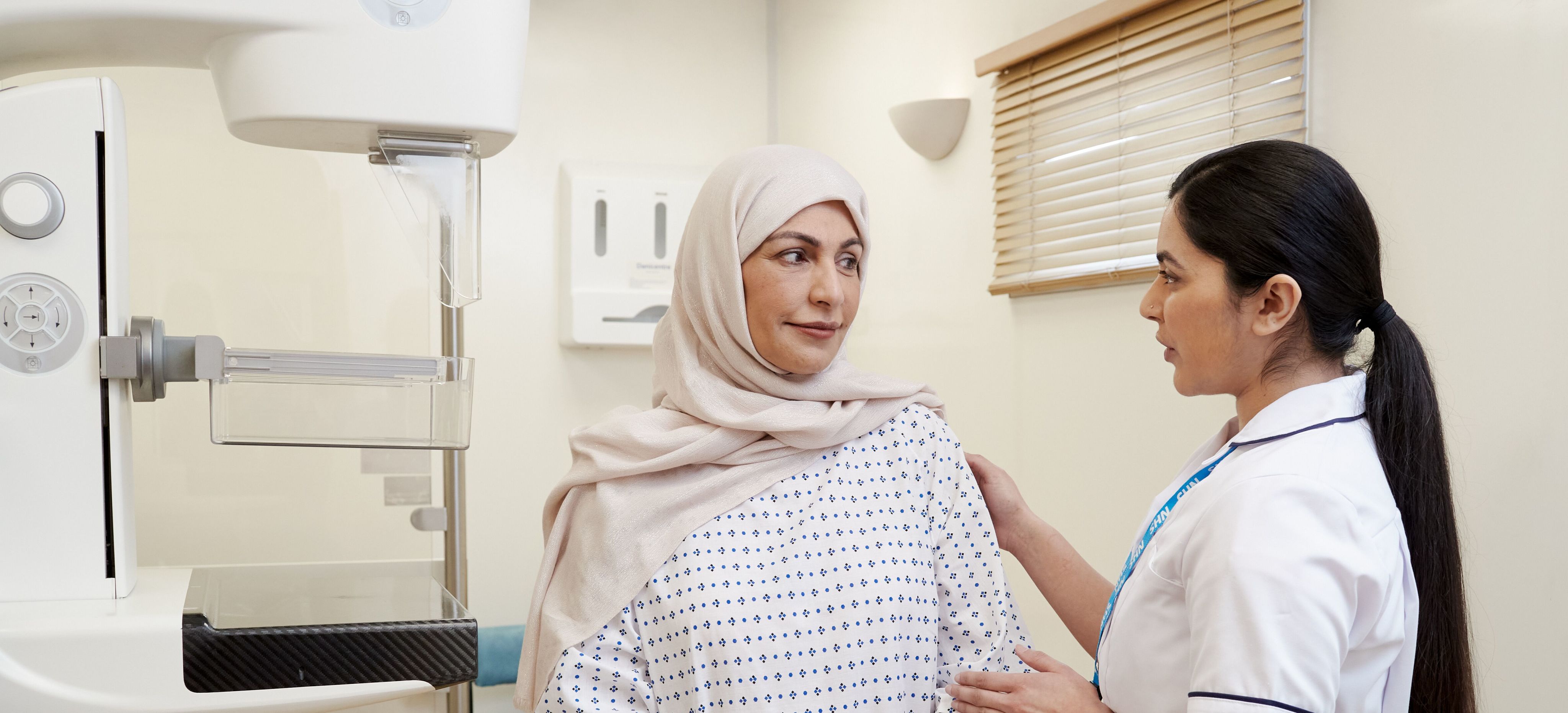 A nurse speaking to a woman at a mammogram appointment