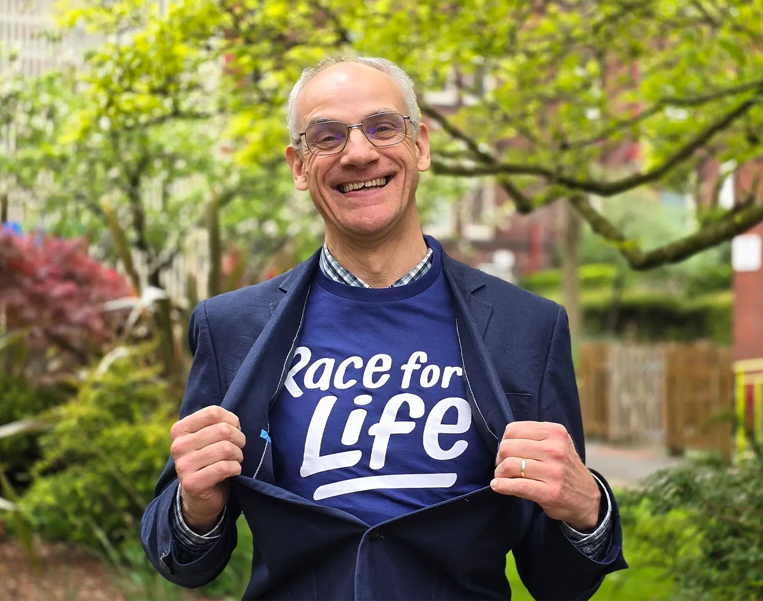 Dr Andrew Peet wearing a Race for Life t-shirt underneath his suit jacket.
