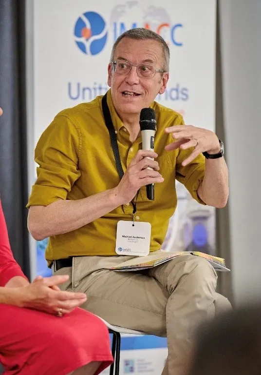 Michael, who took part in our ACT4 trial, speaking at a conference. He's wearing a mustard coloured shirt and speaking into a microphone.