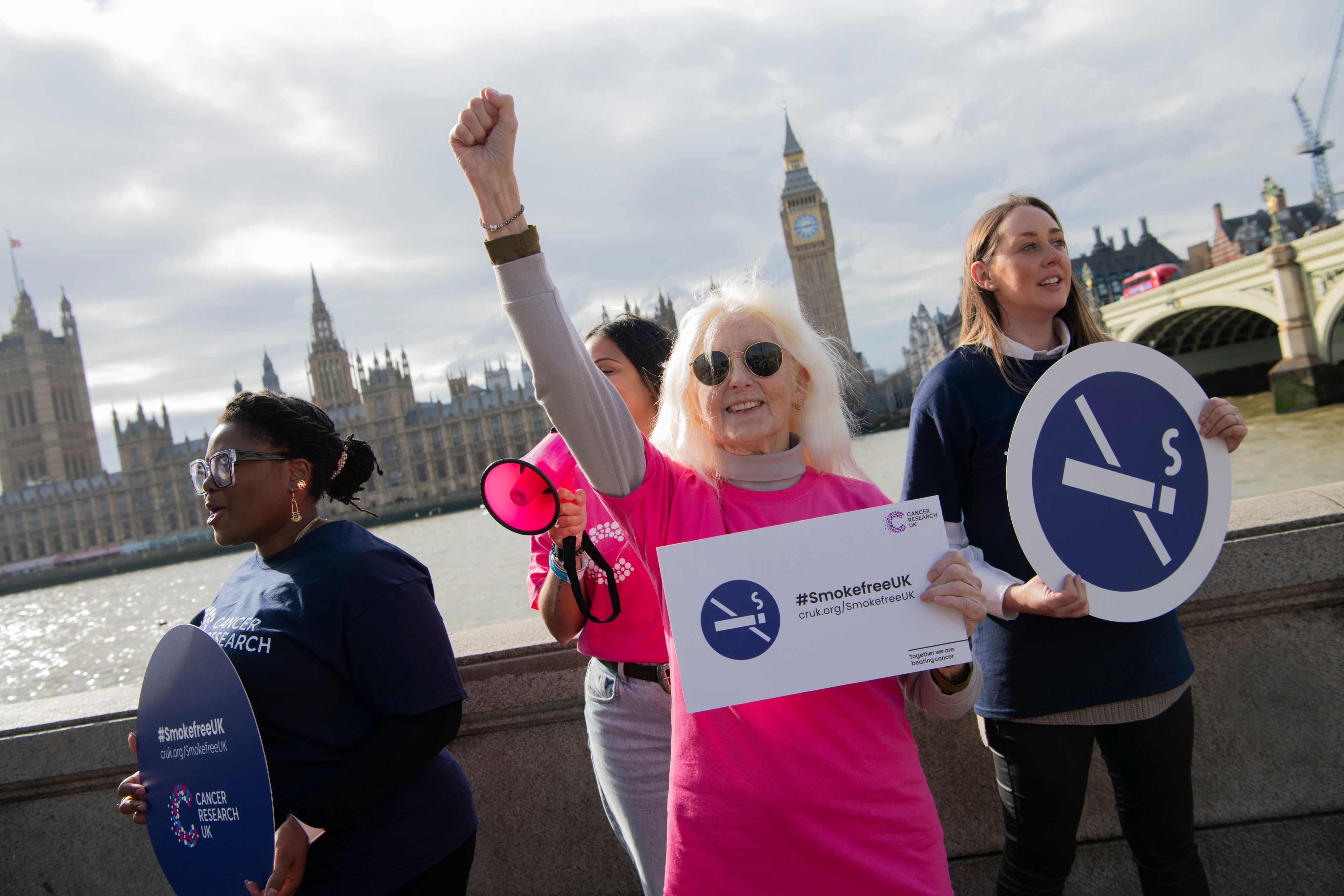 Cancer Research UK Campaigns Ambassadors outside Parliament in London. They are holding signs in support of a Smokefree UK.